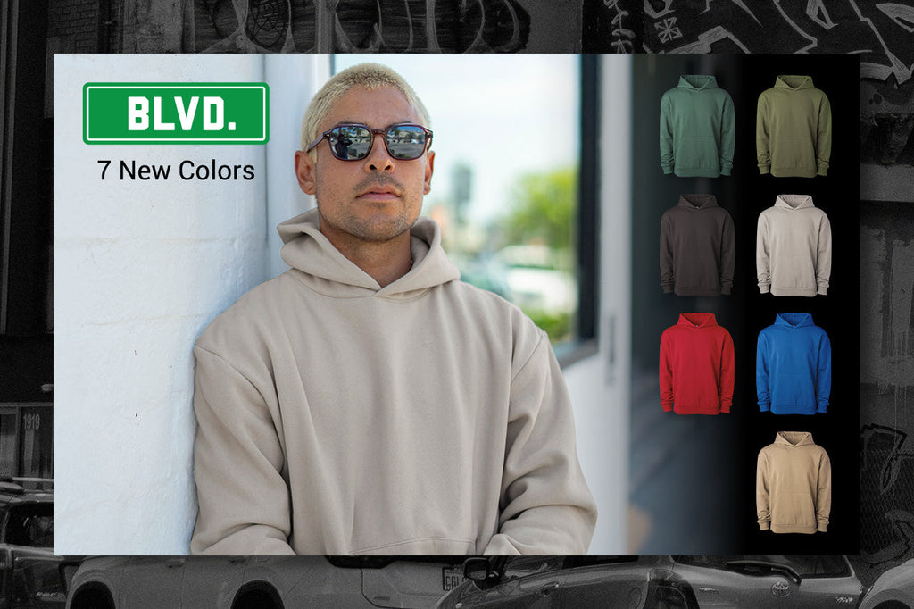 Model wearing the IND330BLV hoodie in Sandstone next to a color swatch grid of all 7 new IND330BLV colorways, with a "BLVD. 7 New Colors" campaign graphic.