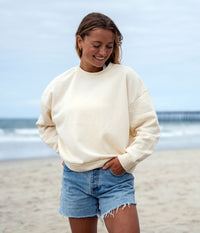 Independent Trading Co. PRM2700 Womens California Wave Wash Sunday Crew Neck Sweatshirt in color Bone on woman at the beach.